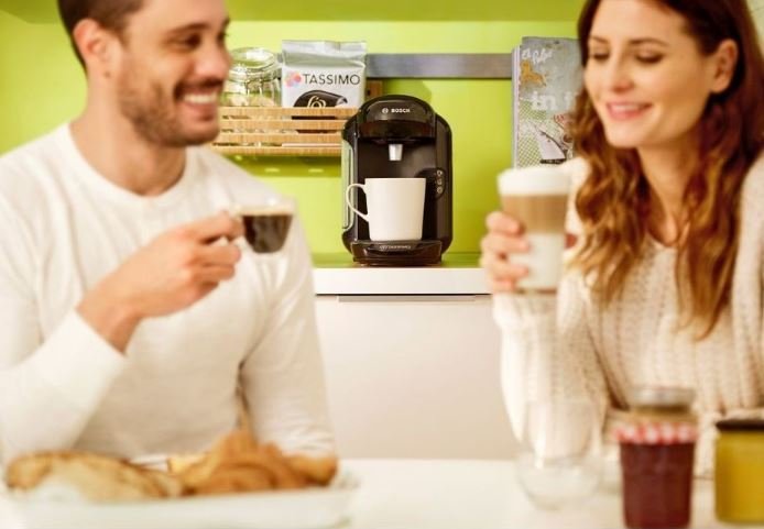 Muž a žena pijí kávu připravenou v Bosch TAS 1402 Tassimo Vivy 2