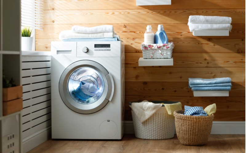 Pračka se sušičkou v prádelně a koše s prádlem