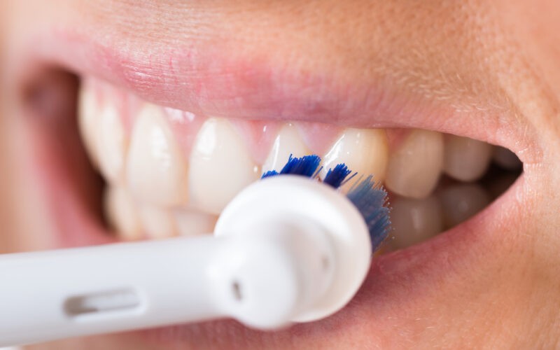 Čištění zubů elektrickým bílým kartáčkem