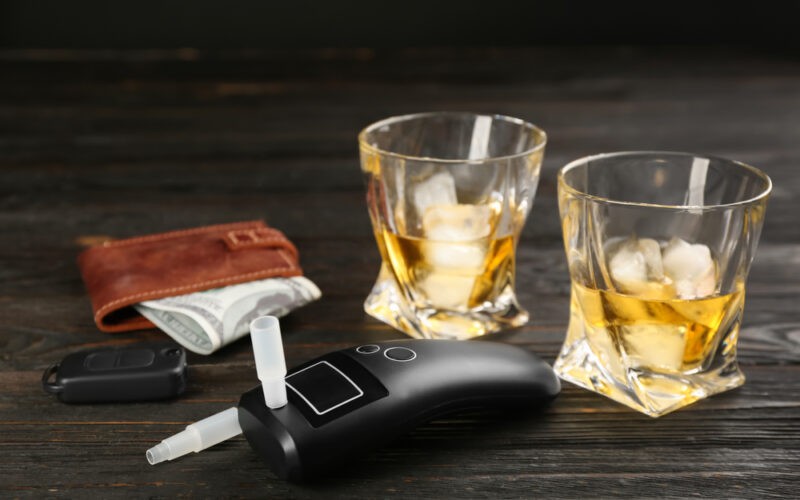 Alkohol tester, alkohol, peněženka a klíče od auta