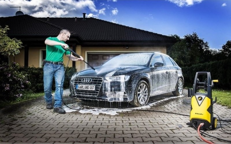 Muž myje auto vysokotlakým čističem