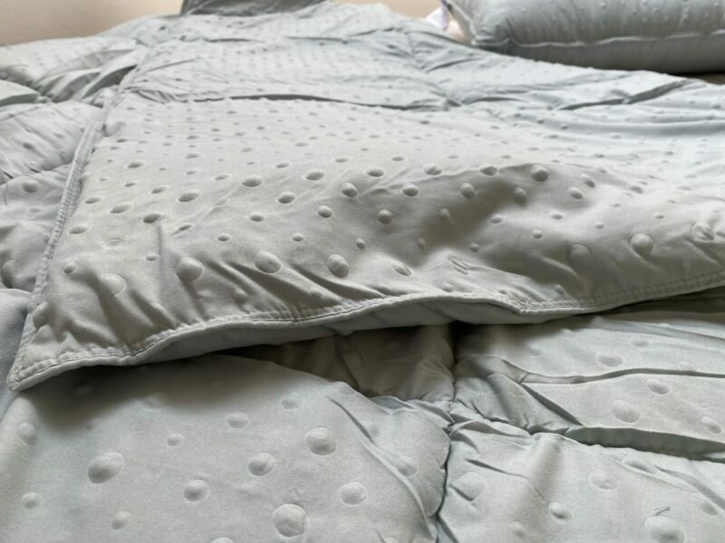 Zelená přikrývka na posteli