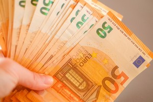 ruka držící euro bankovky