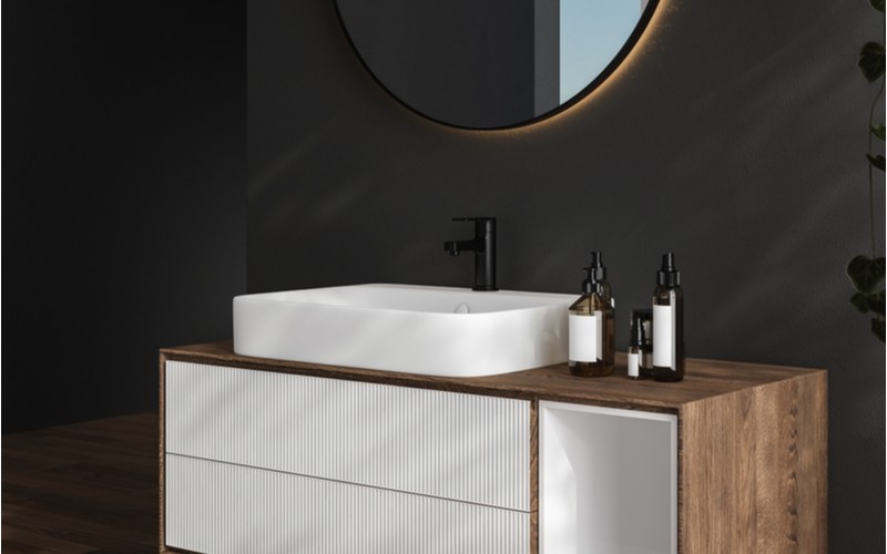 tmavá moderní koupelna s nábytkem v dřevěném dekoru as dřevěnou koupelnovou policí