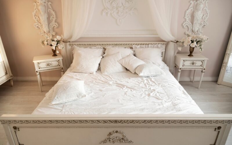 ložnice ve světlých barvách s velkou postelí a dřevěnými nočními stoly