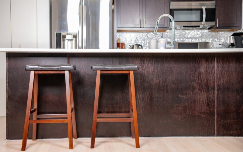 Moderní kuchyně s pultem a dvěma barovými židlemi