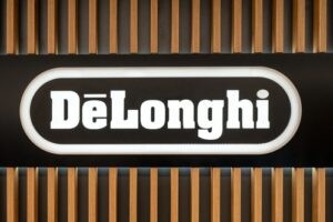 Podsvícené logo DeLonghi na dřevěném mřížkovaným pozadím