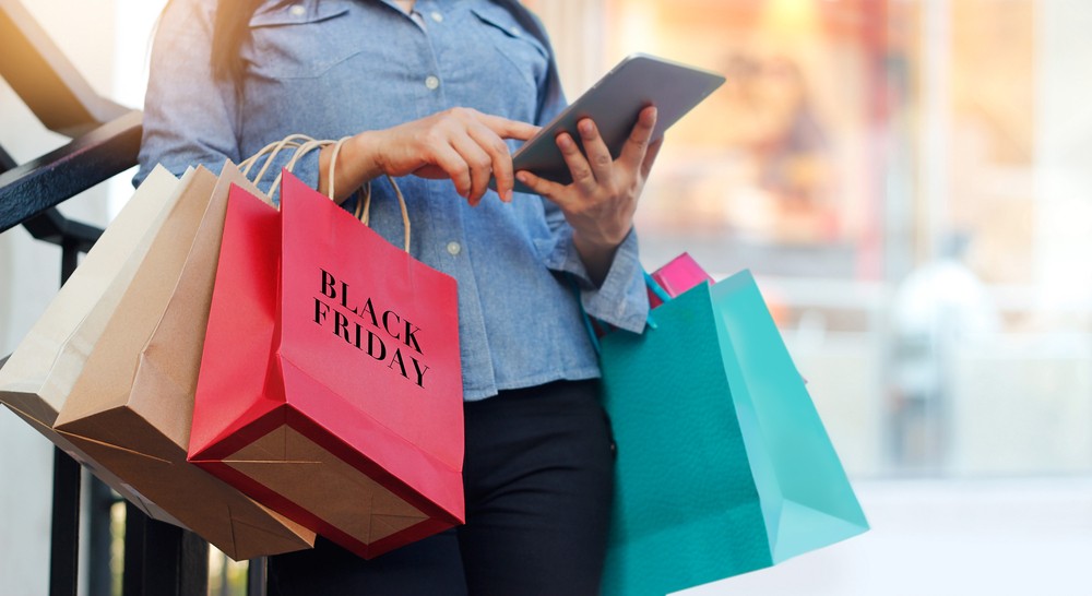 Black Friday 2023 - žena při nakupování drží tablet v ruce a objednává další produkty