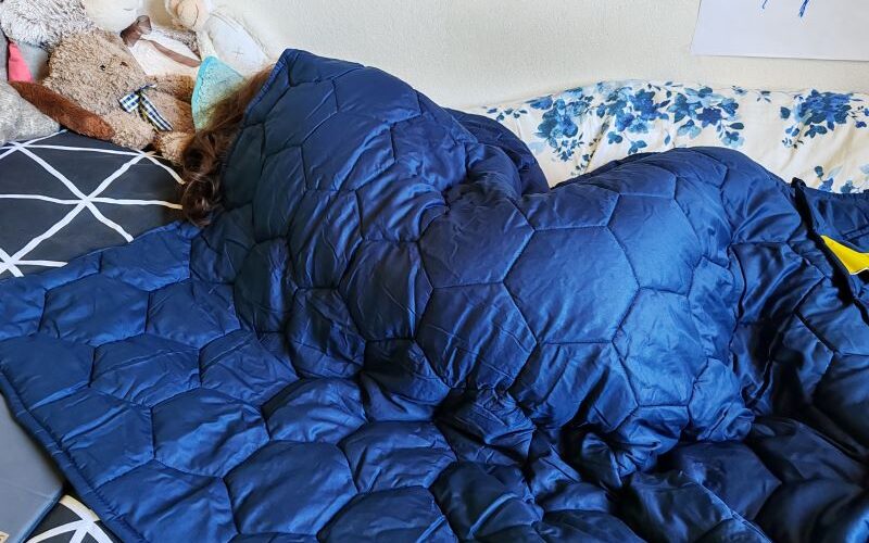 Zátěžová deka Hevi Blanket - pohled na spící osobu pod dekou modré barvy